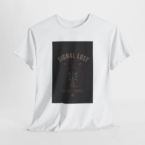 May include: White t-shirt with a black rectangular graphic. The graphic features the text "SIGNAL LOST" above a stylized radio tower design within a red circle. The shirt has short sleeves and a crew neck.