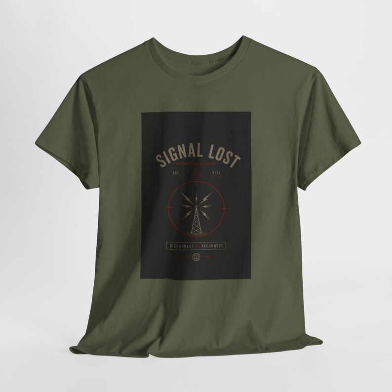 May include: Olive green t-shirt featuring a black rectangle with the words "SIGNAL LOST" in a vintage font. A red circle surrounds a radio tower graphic. The text "DISCONNECT. RECONNECT." is below the graphic. The shirt is made of a soft material.