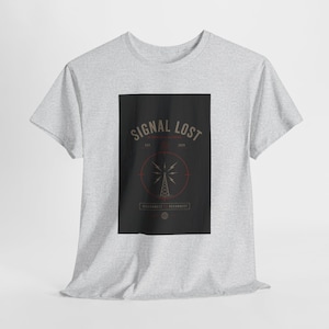 May include: A light gray t-shirt featuring a black rectangle with the words "SIGNAL LOST" in a vintage font. The design includes a radio tower graphic and the text "RECONNECT".