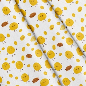 May include: A white fabric featuring a repeating pattern of yellow cartoon potato characters with smiling faces and thin brown limbs, interspersed with small brown candy shapes and scattered yellow dots across the entire surface.