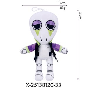K&ouml;nnte beinhalten: Wei&szlig;es Pl&uuml;schtier mit einem stilisierten Alien-Design. Die Puppe hat gro&szlig;e, dunkle Augen, gr&uuml;ne Akzente und eine lila-gr&uuml;n gemusterte Jacke. Sie ist 26 cm hoch und 17 cm breit und wiegt 83g. Der Produktcode lautet X-25138120-33.