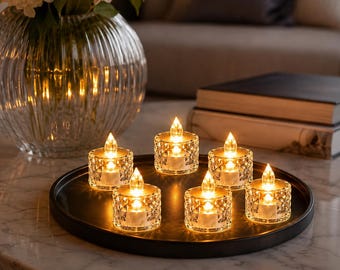 Può includere: Un set di sei lumini a batteria con supporti in vetro trasparente sfaccettato, disposti su un vassoio circolare nero. Ogni candela è dotata di una lampadina LED a forma di fiamma che emette una luce calda e soffusa.