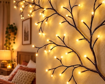 May include: A decorative wall-mounted branch light fixture featuring dark brown textured stems adorned with numerous small, glowing warm white LED bulbs that mimic the appearance of a tree branch illuminated against a plain wall surface.