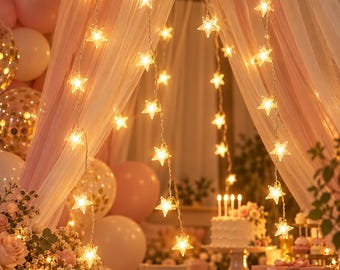 May include: A string of star-shaped LED lights emitting a warm glow, suspended vertically in multiple strands. The clear plastic stars are evenly spaced along thin, flexible wires, creating a decorative lighting display with soft illumination.