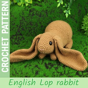 May include: A crocheted English Lop rabbit in shades of brown, with long, floppy ears and black eyes. The rabbit is lying on a bed of green faux grass. The words "CROCHET PATTERN" and "English Lop rabbit" are displayed.