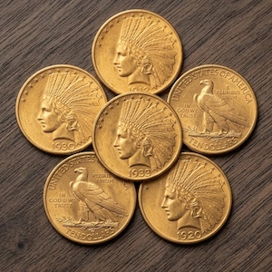 May include: A collection of six gold-coloured coins arranged in a cluster. Four coins feature a profile of a person wearing a feathered headdress with the years 1912, 1920, 1930, and 1933. Two coins display an eagle with the text United States of America.