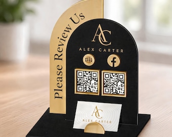 Może przedstawiać: Czarno-złoty stojak z napisem Please Review Us, logo AC Alex Carter, ikoną kuli ziemskiej, ikoną Facebooka, dwoma kwadratowymi kodami QR oraz wizytownikiem z kartą prezentującą logo AC Alex Carter.