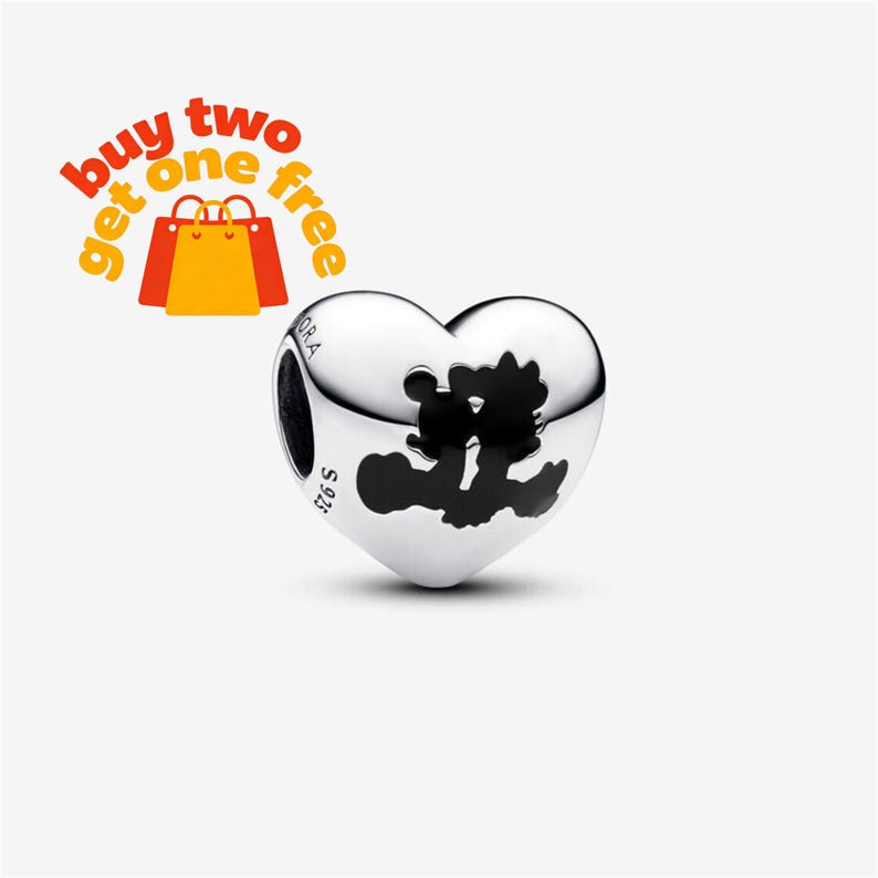 May include: A heart-shaped silver charm bead featuring a black silhouette of two cartoon characters kissing. The metal surface is polished and engraved with the text S925 and PANDORA. The image includes the orange and red text buy two get one free.