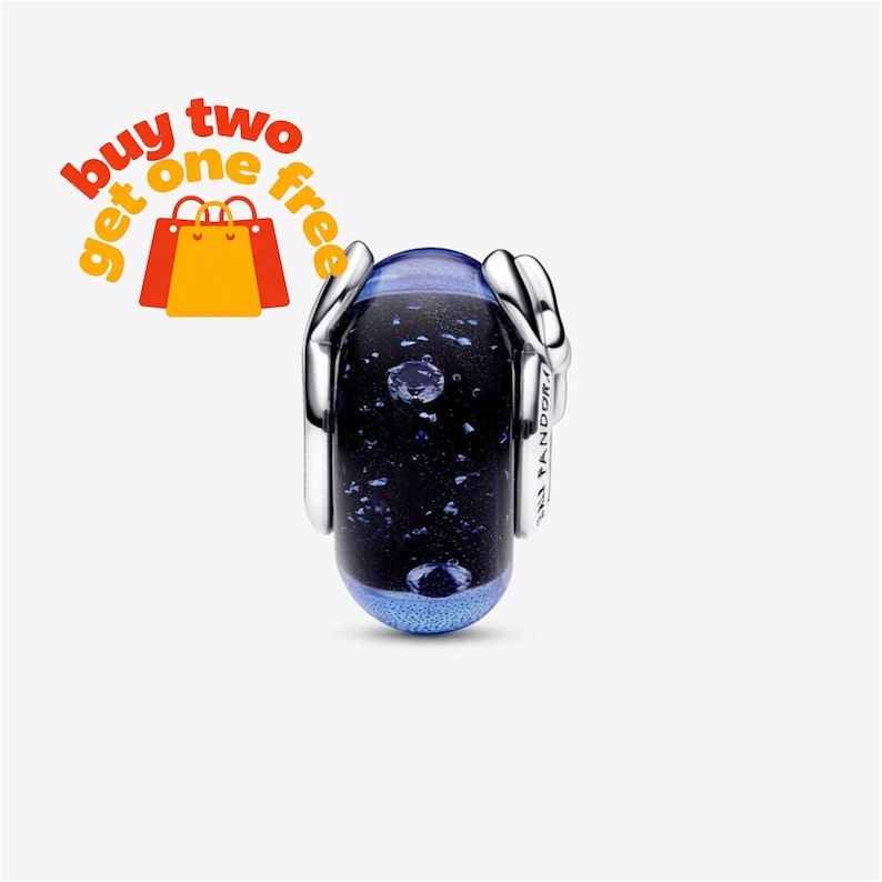 May include: A cylindrical charm bead featuring a dark blue and black glass center with embedded glittery flecks and a textured light blue base. The bead is encased in polished silver-tone metal side caps with the text buy two get one free.