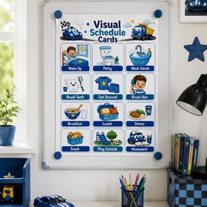 Op de afbeelding: Een wit magnetisch whiteboard met een Visual Schedule Cards-kaart met twaalf geïllustreerde dagelijkse taken voor kinderen, waaronder wakker worden, naar het toilet gaan, handen wassen, tanden poetsen, aankleden, haren kammen, maaltijden en spelen.