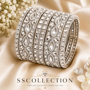 Op de afbeelding: Een stapel zilveren armbanden bezet met heldere, sprankelende edelstenen. De armbanden hebben een mix van ovale en vierkante stenen, gerangschikt in ingewikkelde patronen. De tekst "SS COLLECTION" en "TIMELESS ELEGANCE, MADE FOR YOU" is inbegrepen.