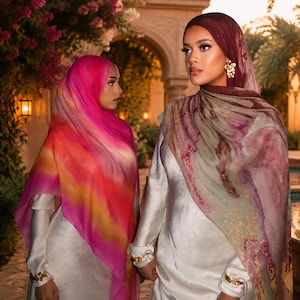 May include: Two individuals wearing long-sleeved white satin dresses and headscarves. One headscarf features a vibrant gradient of pink, orange, and red. The other headscarf displays a muted, marbled pattern of deep burgundy, mauve, and soft grey tones.