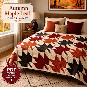 May include: A quilt blanket featuring a repeating pattern of maple leaves in shades of dark brown, rust orange, and cream. The blanket is draped over a bed with two rust-coloured square pillows and one beige square pillow. Text reads Autumn Maple Leaf QUILT BLANKET.