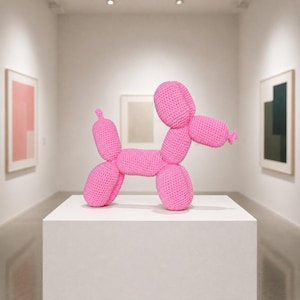 May include: A bright pink crochet sculpture shaped like a balloon dog. The figure is constructed from yarn with a visible stitched texture, featuring a rounded head, elongated snout, cylindrical body, and four legs, mimicking a classic balloon animal.