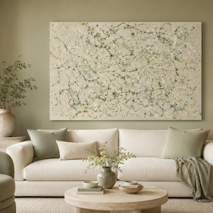 Puede incluir: Un gran cuadro rectangular sobre lienzo con un patrón abstracto de salpicaduras en tonos verde salvia, crema y carbón oscuro. La obra muestra una compleja red de líneas finas y gotas de pintura sobre un fondo de color neutro.