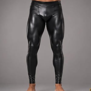 Puede incluir: Leggings negros ajustados con un acabado brillante similar al cuero. Estos pantalones presentan un diseño de cintura alta con una pretina reforzada y una costura central en la parte delantera que va desde la cintura hasta los tobillos.