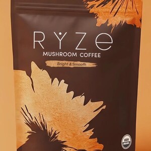 K&ouml;nnte beinhalten: Ein dunkelbrauner Beutel mit RYZE-Pilzkaffee mit wei&szlig;em Text. Der Beutel hat ein orange-braunes Design. Der Text "Bright & Smooth" steht unter dem Produktnamen. Der Beutel enth&auml;lt 180g Produkt.