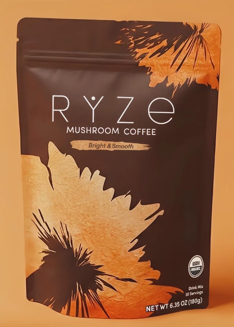 K&ouml;nnte beinhalten: Ein dunkelbrauner Beutel mit RYZE-Pilzkaffee mit wei&szlig;em Text. Der Beutel hat ein orange-braunes Design. Der Text "Bright & Smooth" steht unter dem Produktnamen. Der Beutel enth&auml;lt 180g Produkt.