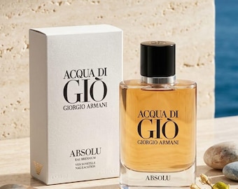 May include: A glass bottle of Acqua Di Gio Giorgio Armani Absolu fragrance with a black cap, featuring amber-colored liquid inside. Next to it stands a white rectangular box with the same branding text printed in black, including the word Absolu.