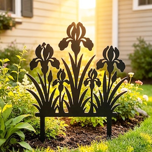 May include: A black metal garden stake featuring a silhouette design of three blooming iris flowers with long, pointed leaves. The decorative piece has two prongs at the base for insertion into the ground, showcasing a flat, solid dark finish.