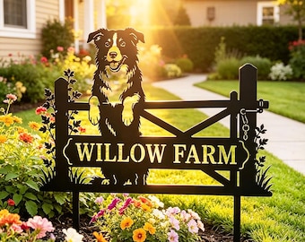 Könnte beinhalten: Ein schwarzes Metall-Gartenschild mit einem Hunde-Ausschnitt, der über einen Zaun schaut, und dem Text WILLOW FARM in der Mitte. Das Schild verfügt über dekorative Blattverzierungen an den Seiten und ein Riegeldetail am rechten Pfosten.