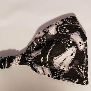 May include: Black and white headband with a repeating pattern of ghosts and the word "Boo".