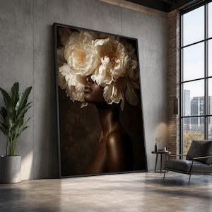 Puede incluir: Una gran obra de arte mural rectangular enmarcada que muestra el retrato de una persona de piel oscura, cuya cabeza está oculta por un denso arreglo de grandes flores de peonía de color blanco crema sobre un fondo marrón oscuro y texturizado.