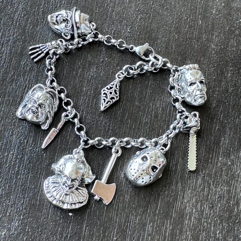 Puede incluir: Pulsera de plata con dijes de personajes de pel&iacute;culas de terror, incluyendo Jason Voorhees, Freddy Krueger, Leatherface y Pennywise. La pulsera tambi&eacute;n incluye un peque&ntilde;o dije de hacha y un dije en forma de diamante.