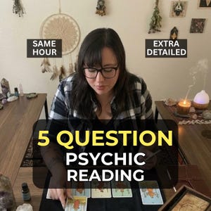 以下が含まれることがあります： メガネをかけた人がテーブルに座り、霊視を行っています。画像には「5 QUESTION PSYCHIC READING」というテキストと、「SAME HOUR」と「EXTRA DETAILED」という追加テキストが表示されています。タロットカードが黒い面に並べられています。