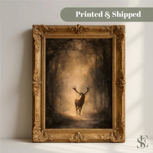 May include: A framed wall art piece featuring a deer standing in a misty, dark forest. The artwork is enclosed in an ornate, antique-style gold frame with intricate carvings. The text "Printed & Shipped" appears in a green banner at the top.