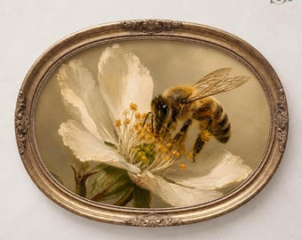 Può includere: Un'opera d'arte da parete con cornice ovale che raffigura un dipinto dettagliato di un'ape su un fiore bianco. L'ape ha del polline giallo visibile sulle zampe e sul corpo, mentre il fiore mostra stami gialli in risalto su uno sfondo tenue.