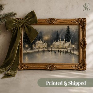 May include: A rectangular landscape painting in an ornate gold frame, featuring a snowy village scene with people ice skating on a frozen pond. A large, olive green velvet bow is attached to the upper left corner of the frame.