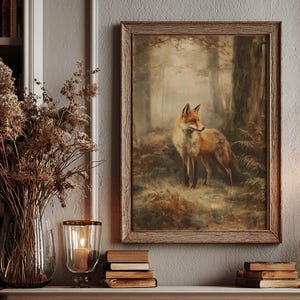 May include: A rectangular framed wall art print featuring a painting of a red fox standing in a misty, wooded forest. The fox is positioned in the center of the composition, surrounded by dark trees, ferns, and earthy, muted tones of brown and green.