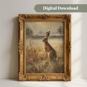 May include: A framed wall art print featuring a brown hare sitting in a field of tall, dry grasses under a soft, overcast sky. The artwork is encased in an ornate, antique-style gold frame with intricate scrollwork and decorative relief details.