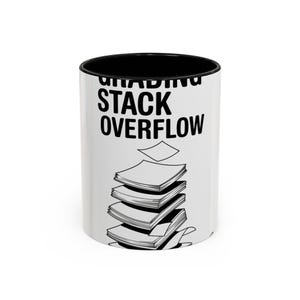 May include: White ceramic mug with a black interior and rim. The mug features the words "GRADING STACK OVERFLOW" in black, along with a stack of papers graphic. A humorous design for teachers or students.