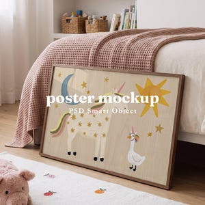 May include: A rectangular wooden frame containing a poster with a light wood grain background. The artwork features a white unicorn with gold stars, a blue crescent moon, a yellow sun, and a white goose wearing a unicorn horn. Text reads poster mockup.