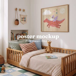May include: A rectangular poster mockup featuring a pink dragon with purple wings carrying a white bird, set against a light background with clouds and stars. The artwork is displayed in a wooden frame above a wooden toddler bed with striped bedding.