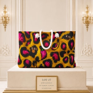 May include: A rectangular tote bag featuring a vibrant yellow, black, and hot pink leopard print pattern with small monkey illustrations and chili peppers. The bag has two thick white rope handles knotted at the top for carrying purposes.