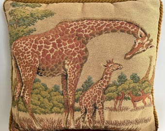 Cojín decorativo Ashford Court con tapiz jacquard de una jirafa madre con su cría y ribete de cordón trenzado.