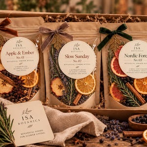Peut inclure: Un coffret cadeau contenant trois sachets en papier kraft étiquetés Isa Botanics Apple & Ember No. 01, Slow Sunday No. 02 et Nordic Forest No. 03. Chaque sachet présente un ruban en velours, des fruits séchés, des herbes et des épices.