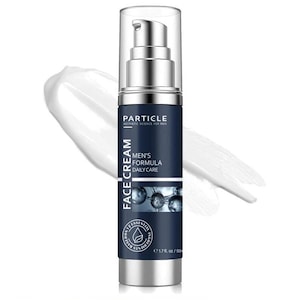Puede incluir: Un frasco de crema facial plateado y azul marino con el texto "PARTICLE" y "MEN'S FORMULA DAILY CARE". El frasco contiene 50 ml de crema, con una mancha de crema blanca en el fondo.