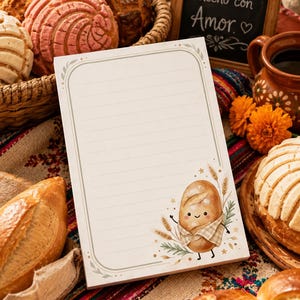May include: A rectangular notepad with horizontal lines and a decorative border featuring a small, illustrated cartoon bread character wearing a checkered apron, surrounded by wheat stalks and greenery on a white background.