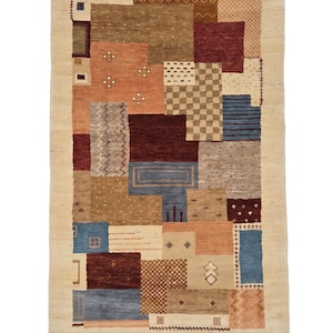Könnte beinhalten: Ein rechteckiger Teppich mit einem Patchwork-Design aus verschiedenen geometrischen Formen in Creme-, Braun-, Rost-, Blau- und Kastanienbrauntönen. Der Teppich zeigt diverse Muster wie Zickzacklinien, Karos und kleine Stickereien mit Fransen.
