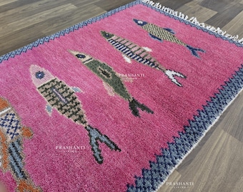 Tapete de lã feito à mão com estampa de carpas koi e borda geométrica rosa vibrante.