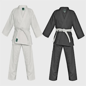 Pode incluir: Dois uniformes de artes marciais, um branco e um preto, cada um composto por uma jaqueta de manga comprida com gola em V e calças a condizer. Ambos os uniformes apresentam um cinto de tecido branco atado à cintura e uma pequena etiqueta verde.