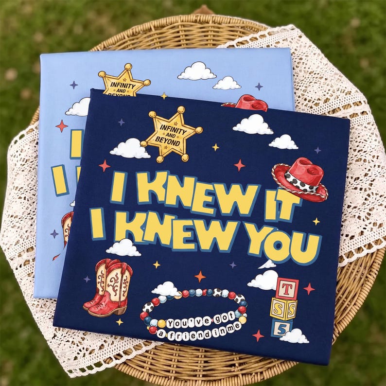 May include: Two square fabric panels featuring cartoon graphics. The top panel is dark blue with the yellow text "I KNEW IT I KNEW YOU," a sheriff star, a red cowboy hat, a pair of cowboy boots, a beaded bracelet, and alphabet blocks. The bottom panel is light blue.