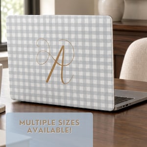 May include: A laptop skin featuring a light grey and white gingham check pattern with a large, gold-coloured cursive letter A centred on the back. The text "MULTIPLE SIZES AVAILABLE!" is printed in gold on a light blue rectangular overlay.