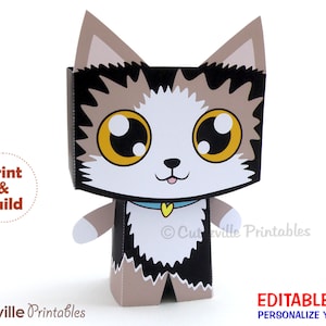 May include: Printable papercraft model of a cartoon cat with brown, black, and white fur. The cat has large eyes, a pink nose, and a blue collar with a yellow heart. The text "Print & Build" is visible in a circle on the left side of the image. The text "Cutezville Printables" is visible at the bottom of the image.
