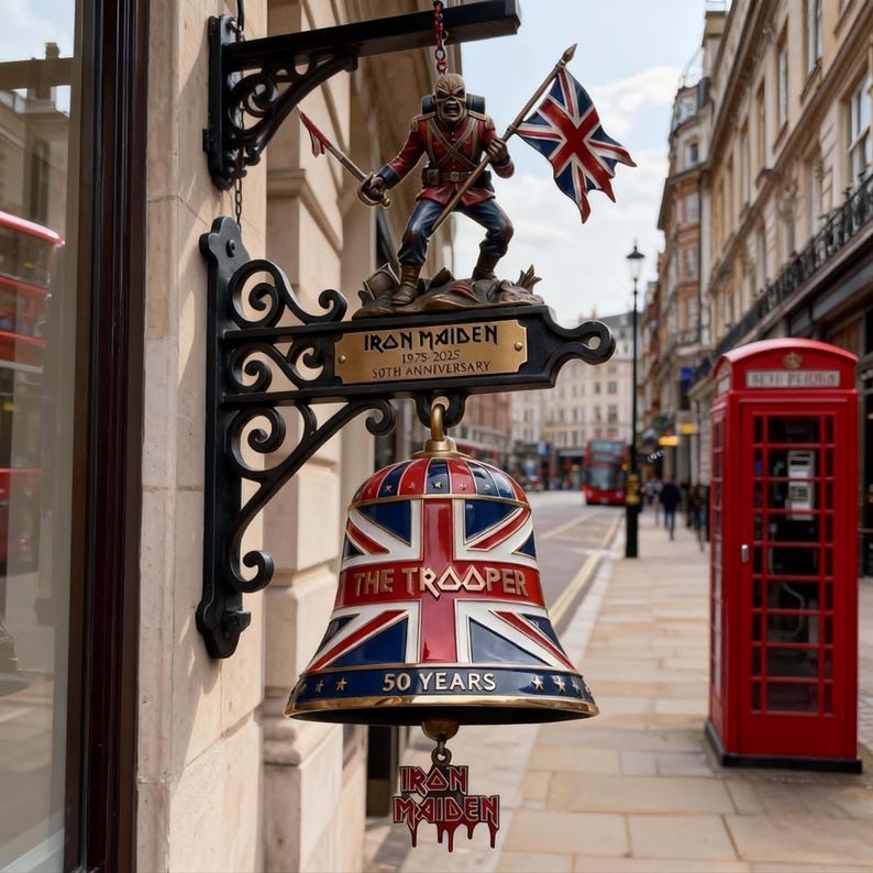 Peut inclure: Enseigne d&eacute;corative Iron Maiden avec une cloche aux couleurs du drapeau britannique, l'inscription "THE TROOPER" et "50 YEARS". Une figurine d'Eddie the Head tient un drapeau et une &eacute;p&eacute;e. L'enseigne est fix&eacute;e sur une fa&ccedil;ade &agrave; Londres.