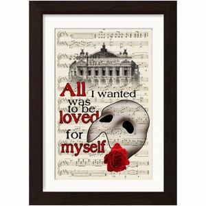 May include: A framed print with a black frame and a white mat. The print features a black and white image of the Paris Opera House, a white Phantom of the Opera mask, and a red rose. The text "All I wanted was to be loved for myself" is printed in black on the print.